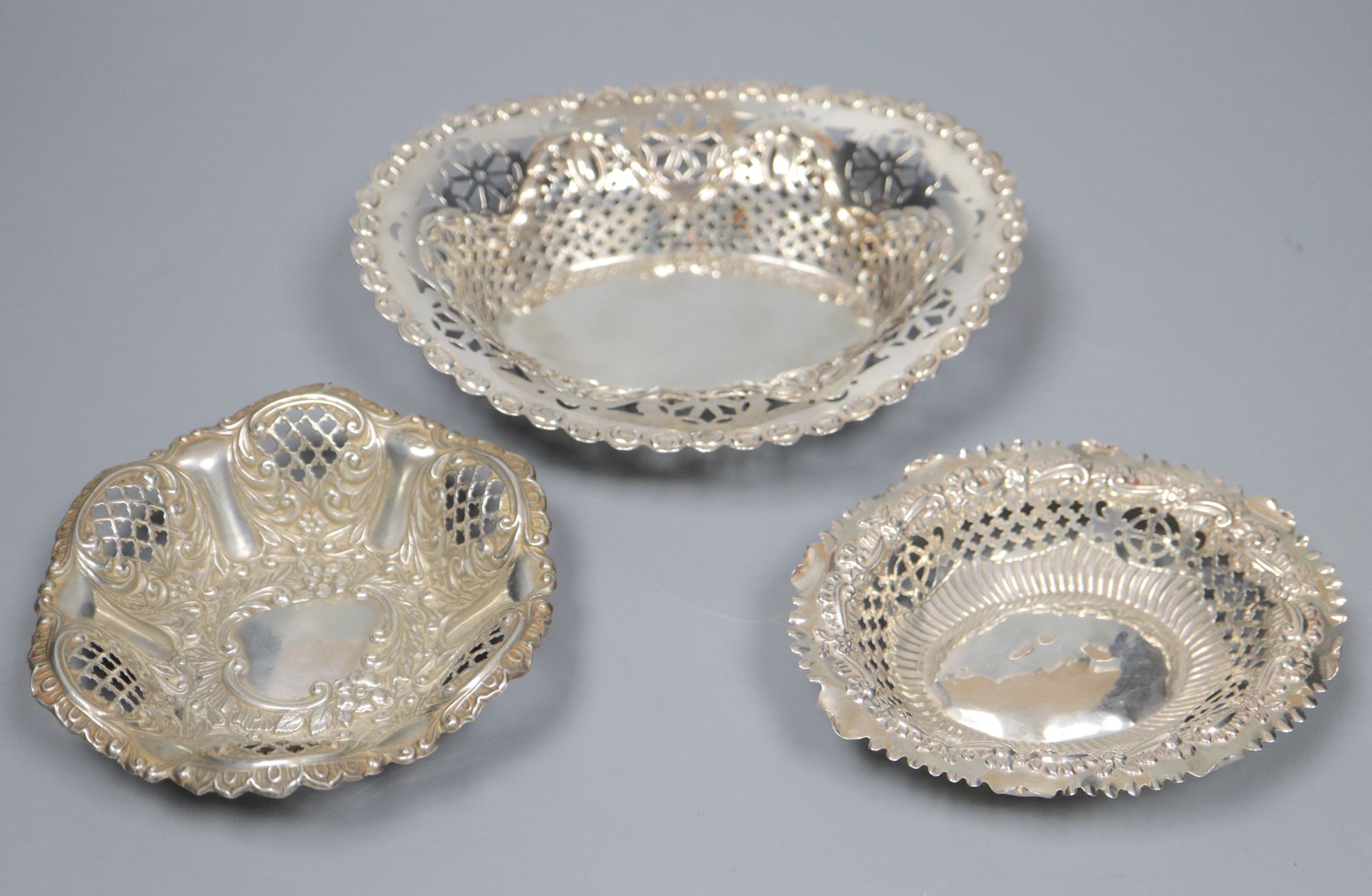 A late Victorian repousse silver bon bon dish and two similar Edwardian dishes, largest 16.8cm, 159 grams.